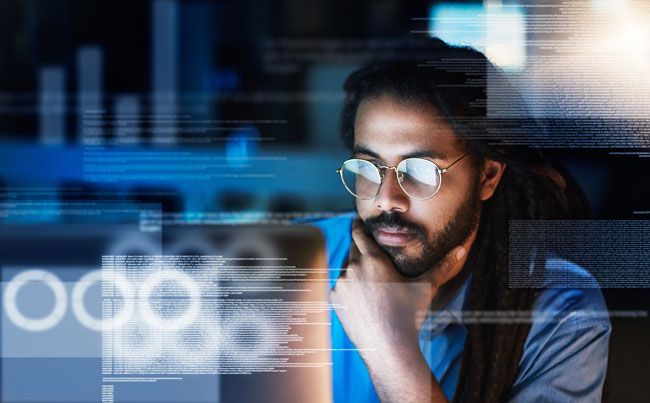 A business owner sits at a desk reviewing the data analytics of his drivers and their use of a fleet card.